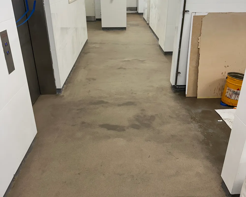 Worn concrete garage floor showing dusting, staining and cracking before epoxy flooring.