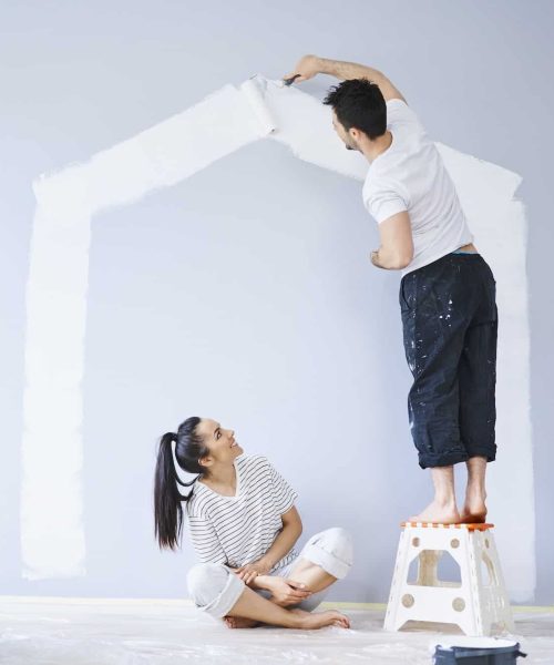 couple-painting-house-shape-on-wall-in-new-apartment.jpg